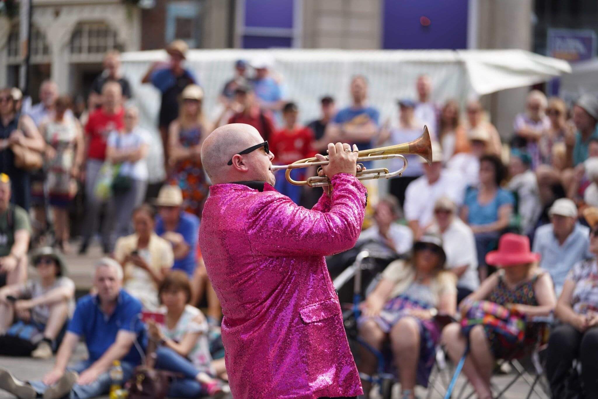 Benny Beavis passionately playing the trumpet Durham Brass Festival in a glittery pink jacket