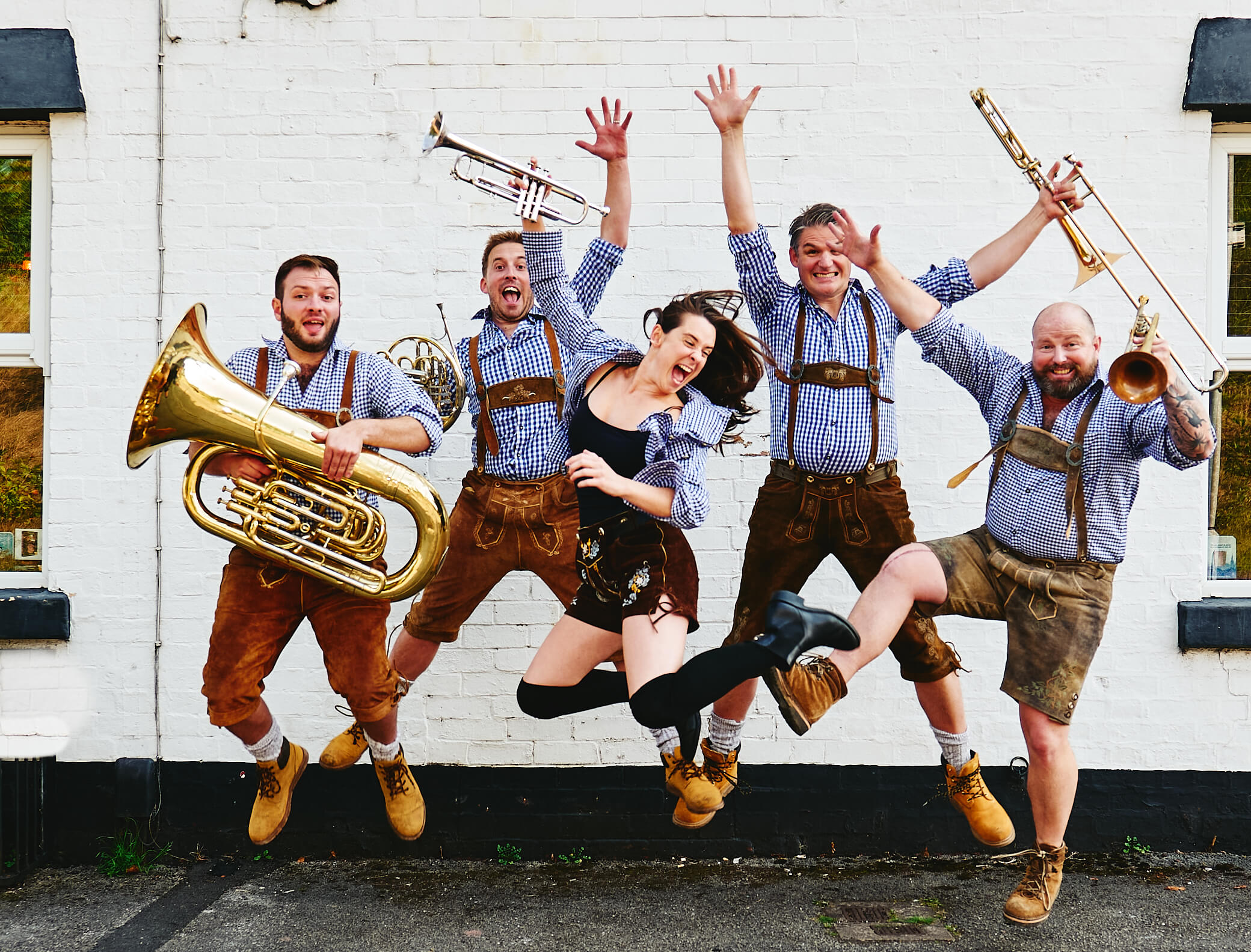 Oompah Brass jumping in the air wearing pink t-shirts at party